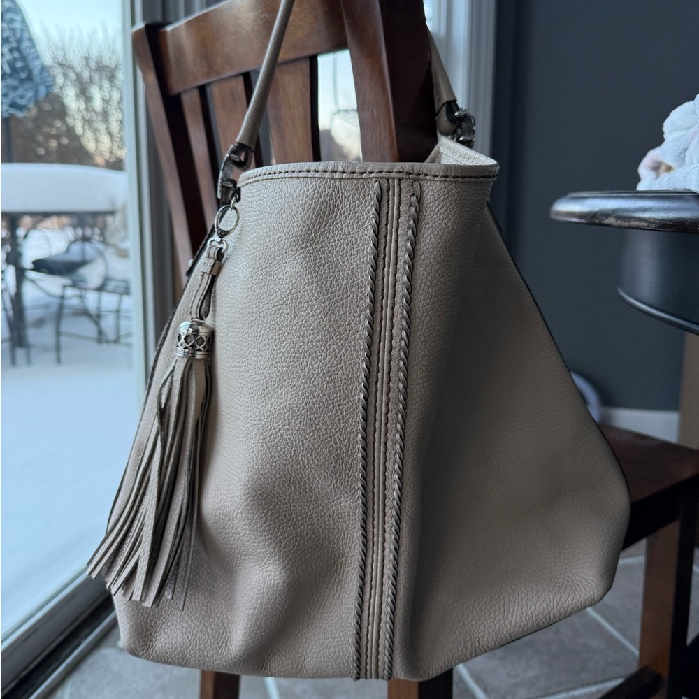 Brighton shoulder bag in a light beige or taupe leather with a tassel
